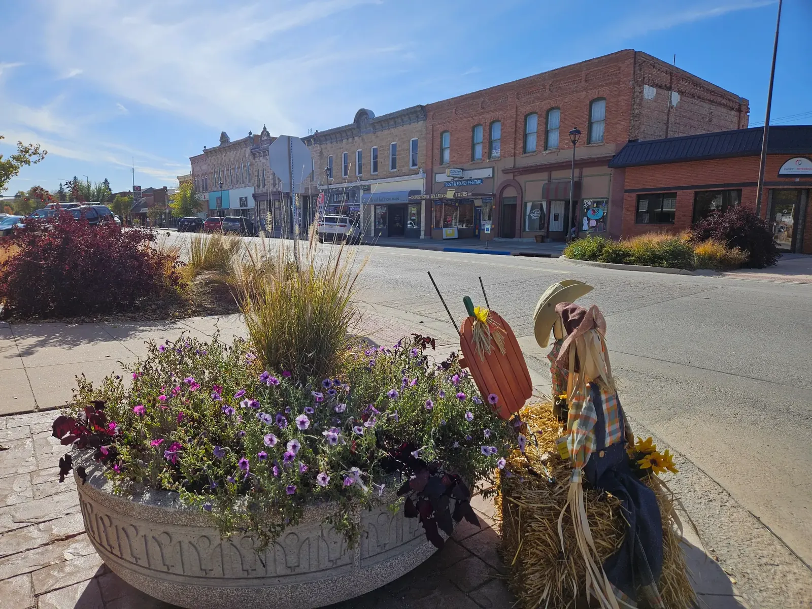 Downtown storefronts with flowers and an autumn display